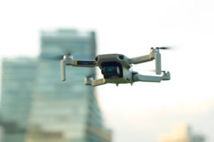 Flying drone with blurred buildings in background